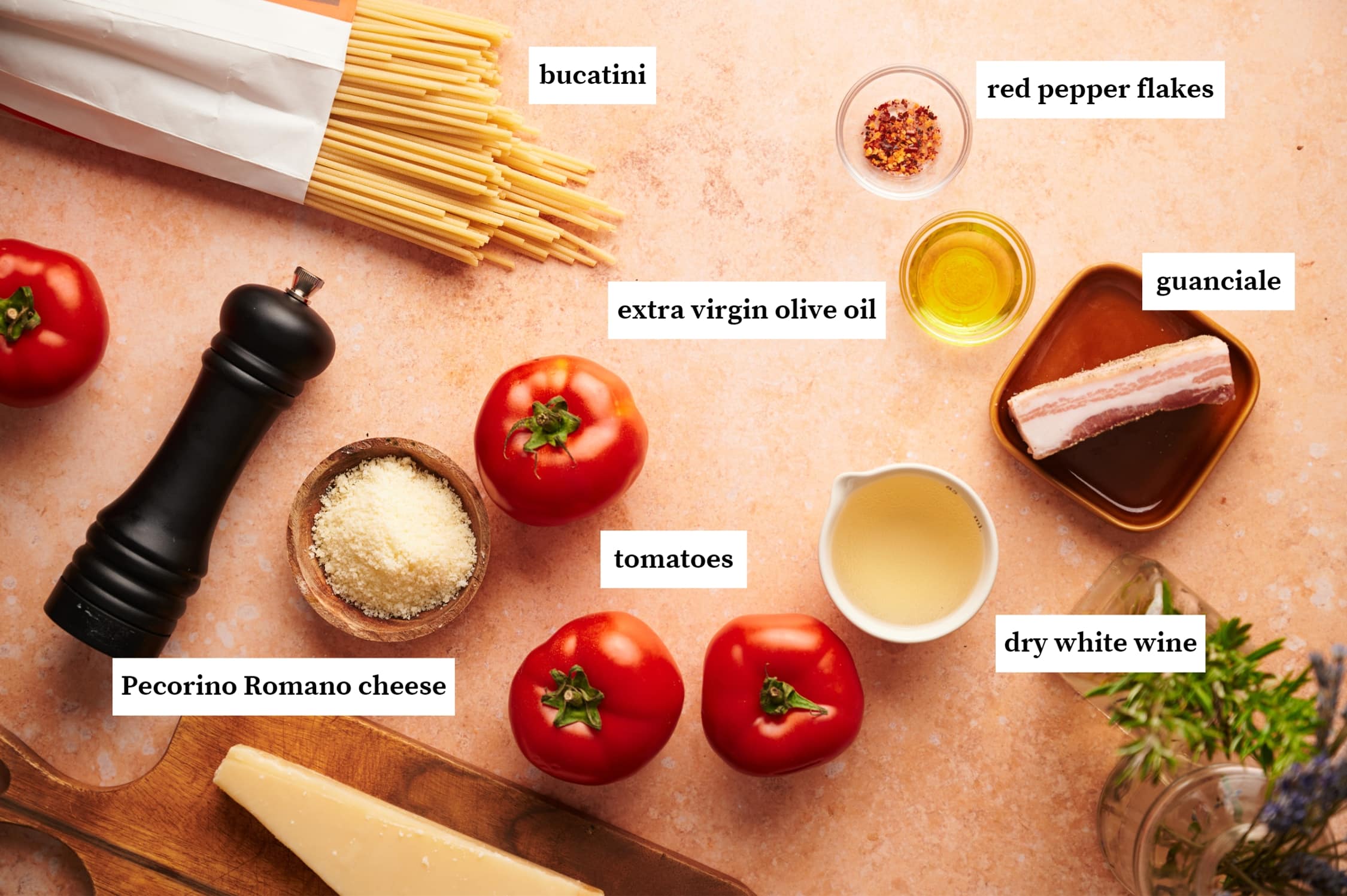 amatriciana ingredients: bucatini pasta in a paper bag, small bowls of red pepper flakes, olive oil, dry white wine, guanciale, tomatoes, cheese