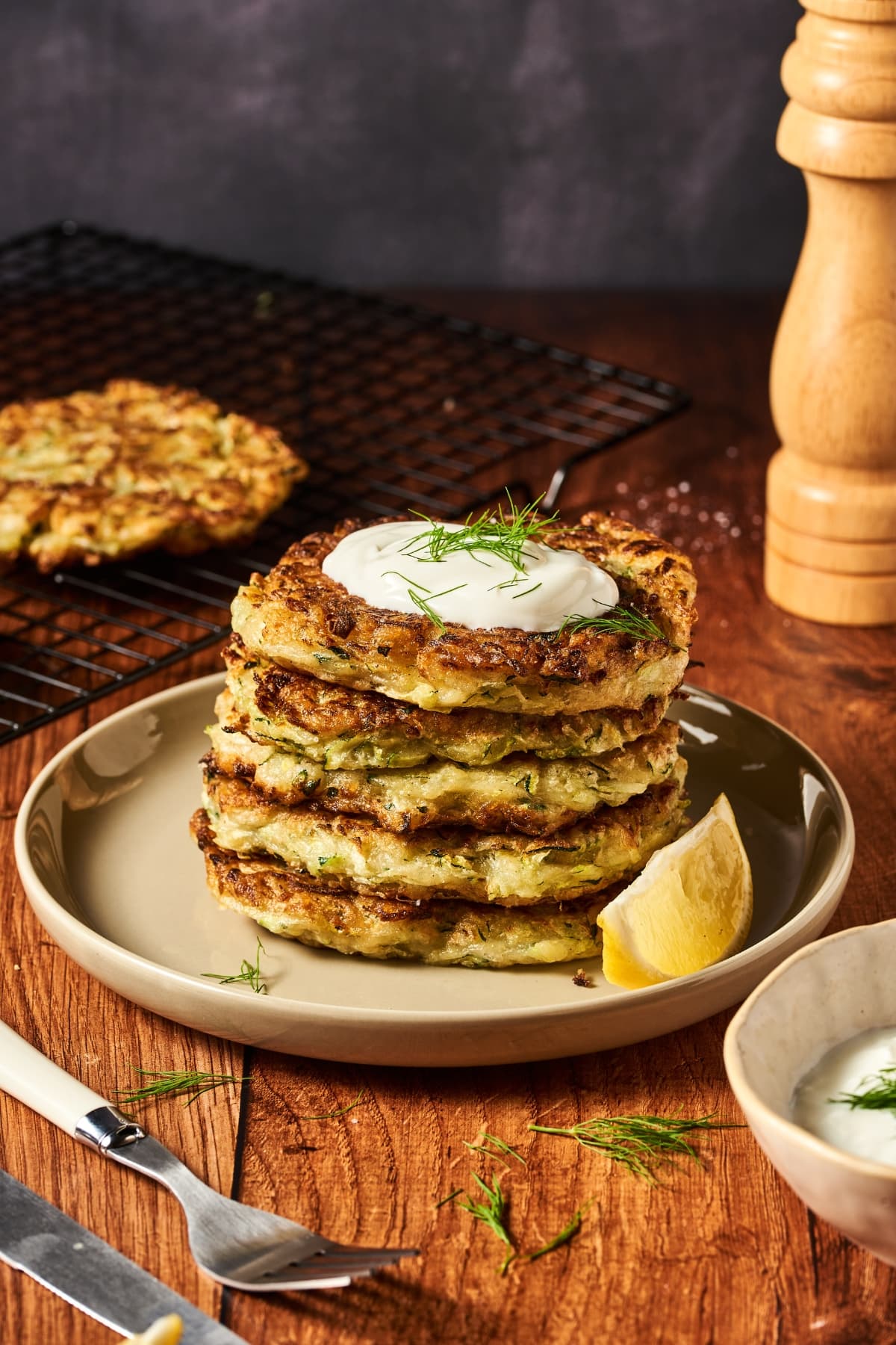 stack of zucchini fritters topped with sour cream