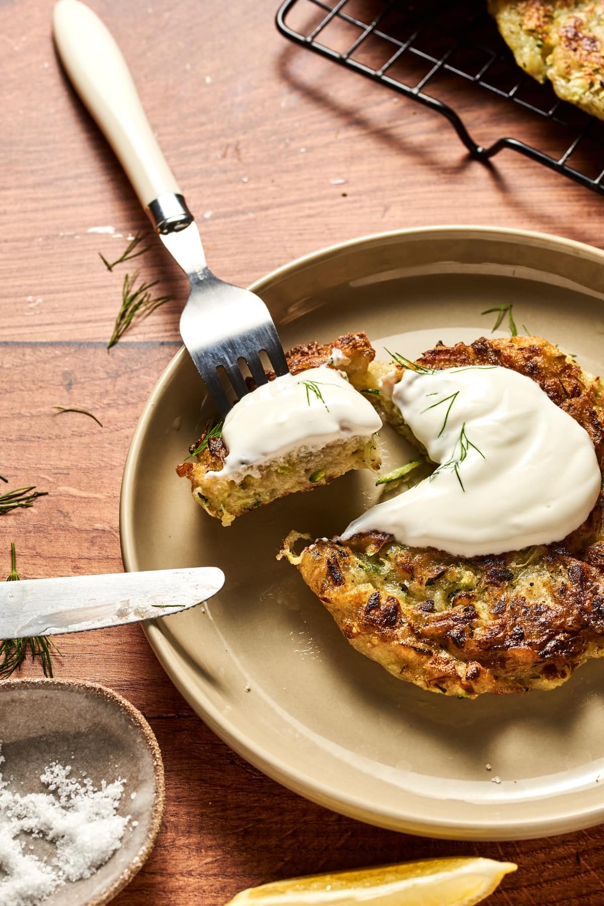 zucchini fritters in a plate with a dallop of sour cream on top