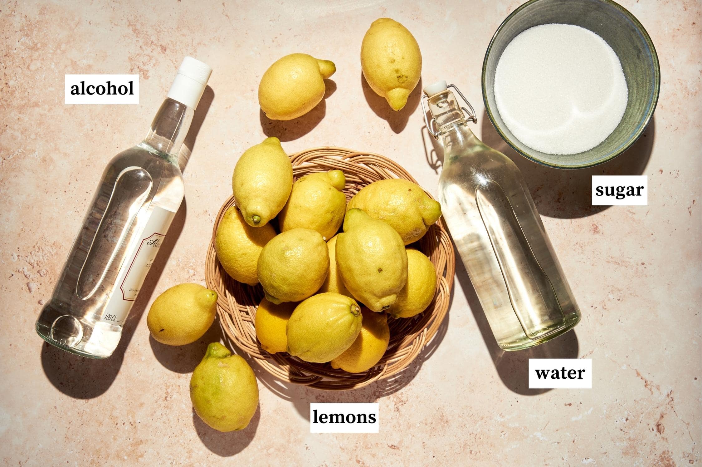 Ingredients for homemade limoncello: lemons, alcohol, sugar and water.