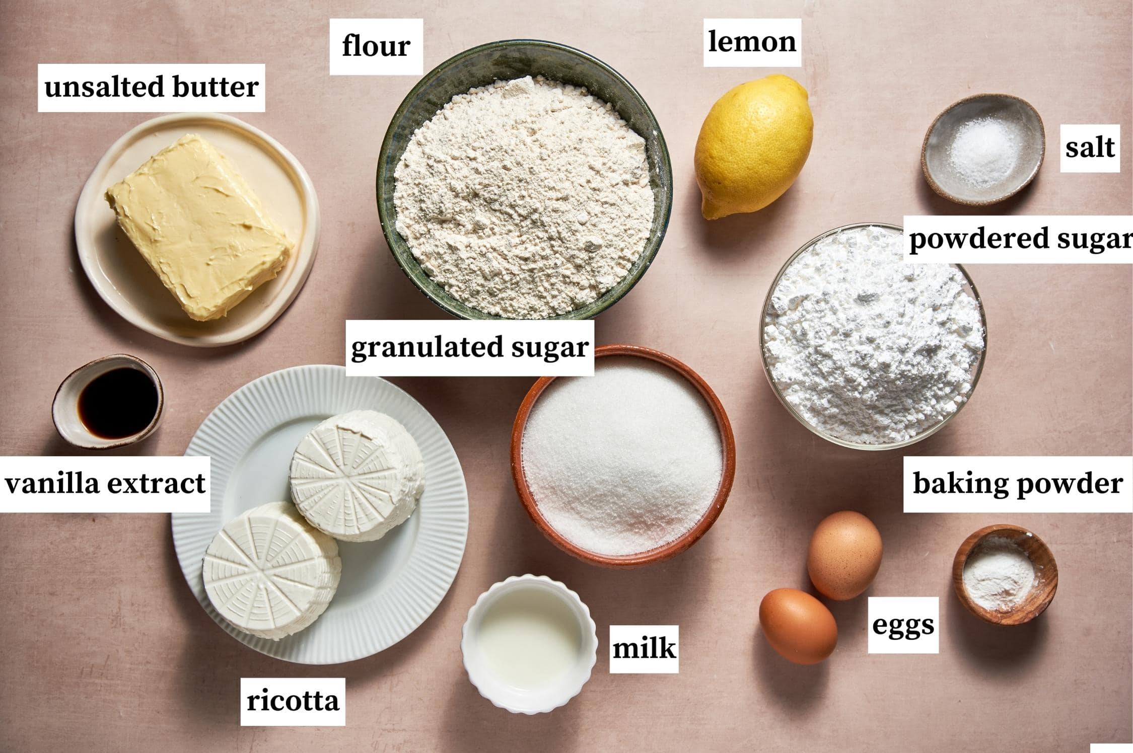Ingredients for ricotta cookies: unsalted butter, flour, lemon, powdered sugar, granulated sugar, baking powder, eggs, milk, ricotta, vanilla extract and salt.