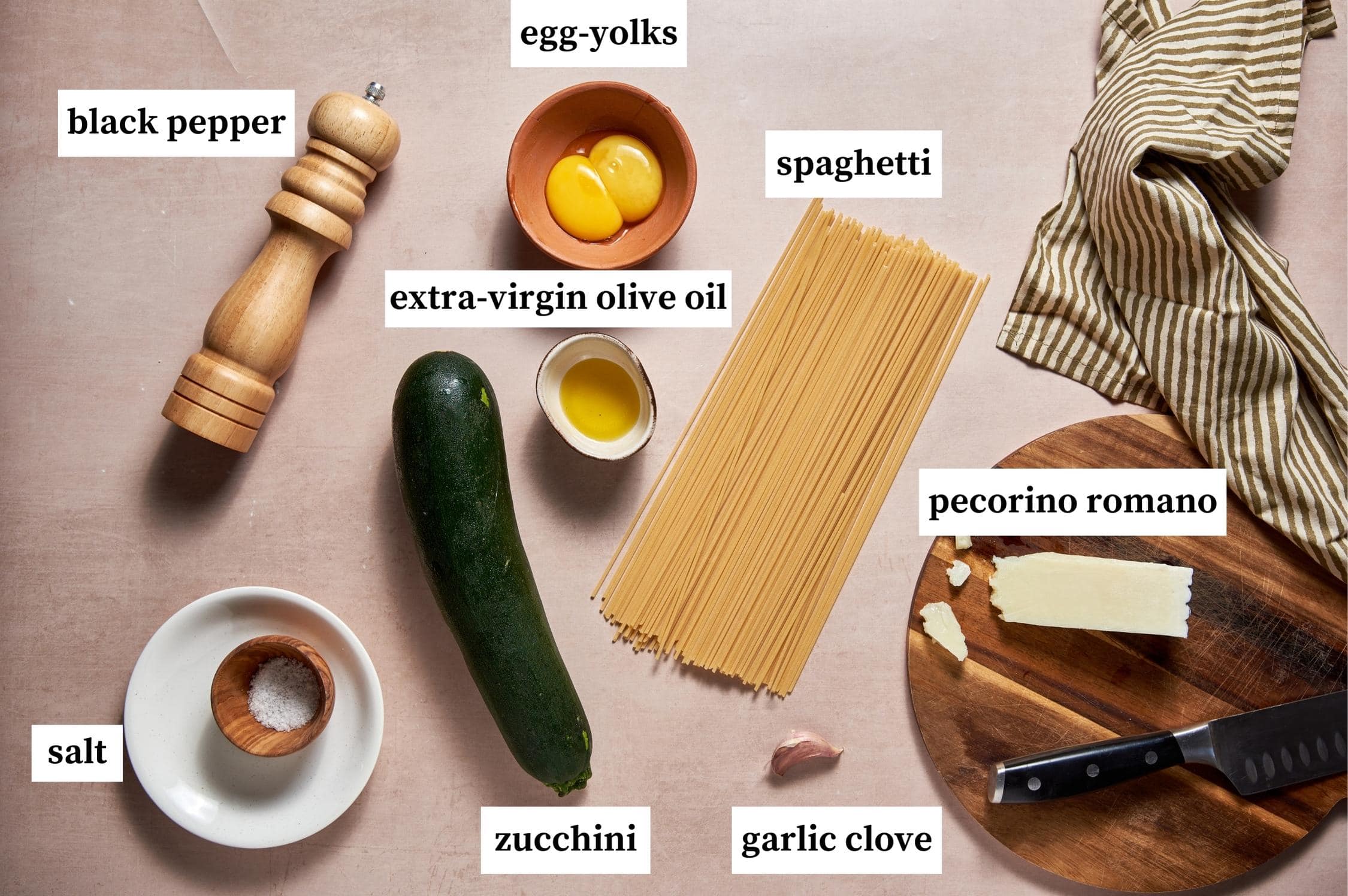 Ingredients for vegetarian carbonara: egg-yolks, spaghetti, pecorino romano, garlic clove, zucchini, extra-virgin olive oil, salt and black pepper.