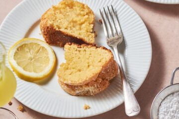 slices of limoncello cake on a white plate with a slice of lemon and a fork