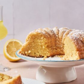 sliced limoncello cake on a cake stand.