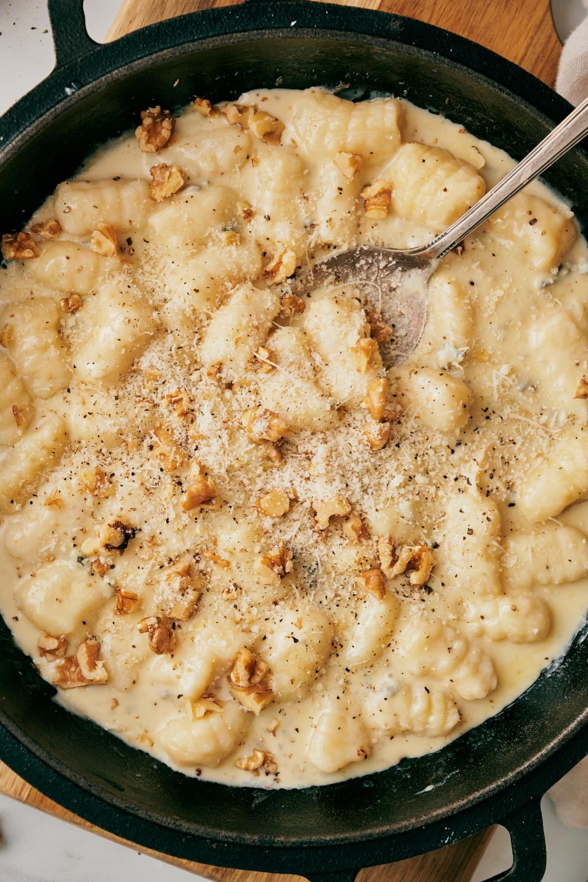 gnocchi with gorgonzola on a skillet with a silver spoon